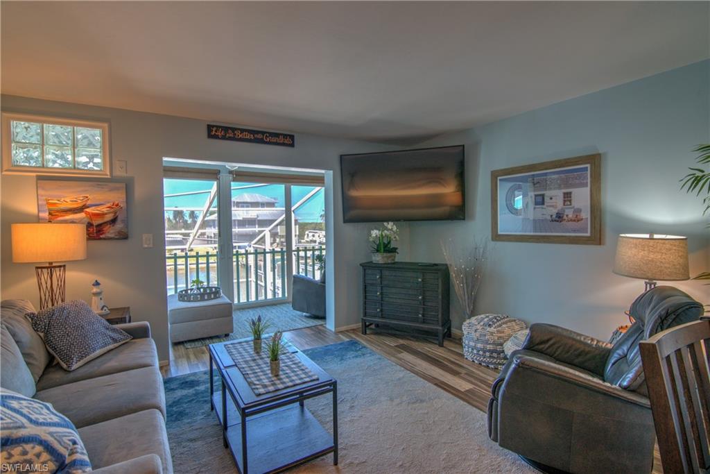 3215 Stringfellow Road, Unit 2A St. James City, FL 33956 - Photo 6 of 31 a living room with furniture a flat screen tv and a fireplace