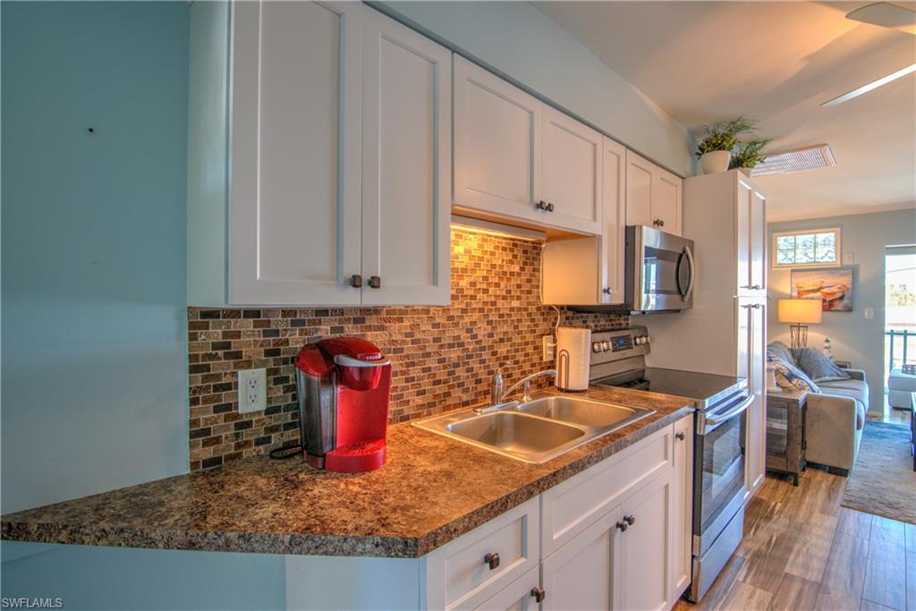 3215 Stringfellow Road, Unit 2A St. James City, FL 33956 - Photo 9 of 31 a kitchen with stainless steel appliances granite countertop a sink stove and cabinets