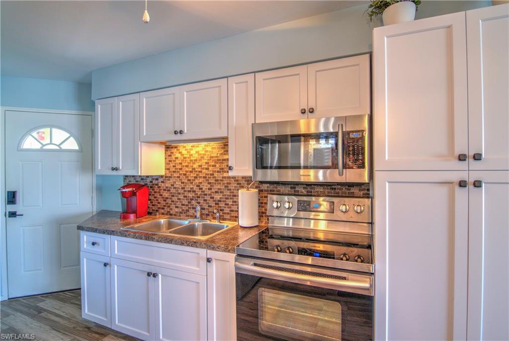 3215 Stringfellow Road, Unit 2A St. James City, FL 33956 - Photo 10 of 31 a kitchen with stainless steel appliances a stove and a refrigerator