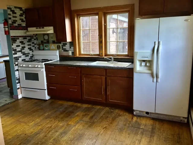 a kitchen with stainless steel appliances a stove a refrigerator and a window