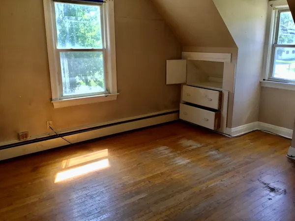 a view of an empty room with wooden floor