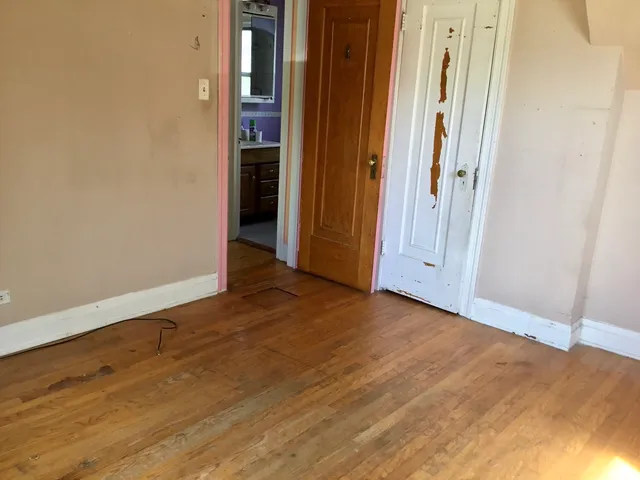 a bathroom with a granite countertop toilet a sink and a window