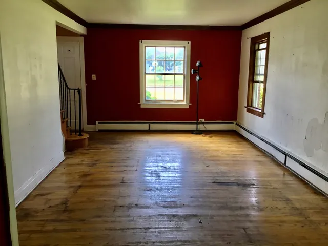 a view of an empty room with glass door and wooden floor