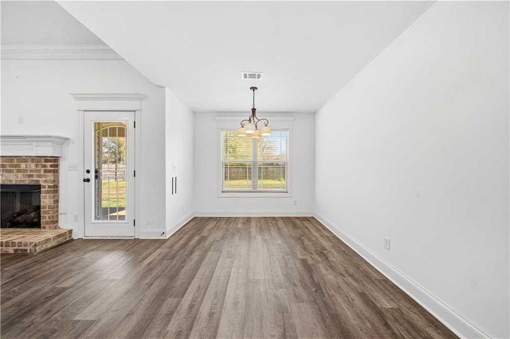 108 Watts Drive Perry, GA 31069 - Photo 17 of 34 an empty room with wooden floor a fireplace and windows