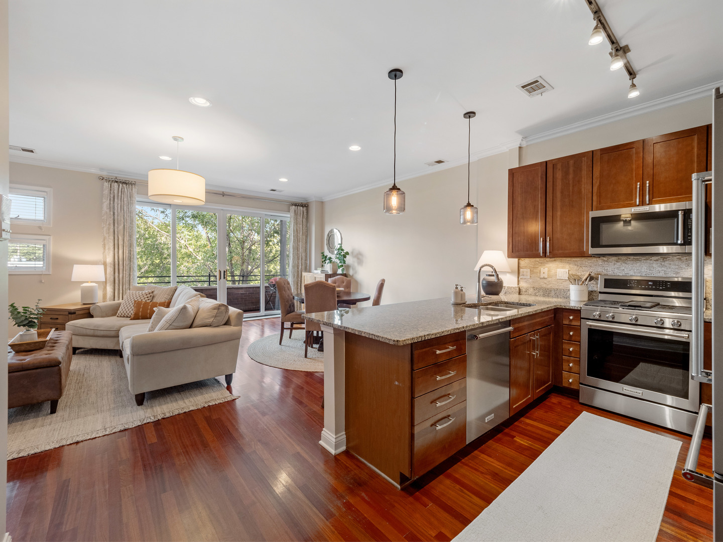 1925 West Irving Park Road, Unit 3 Chicago, IL 60613 - Photo 6 of 26 a large kitchen with stainless steel appliances granite countertop a stove a sink dishwasher a microwave oven and a dining table with wooden floor