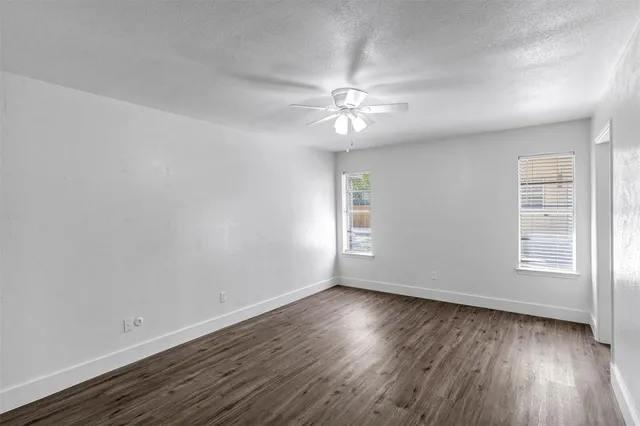 an empty room with wooden floor and window