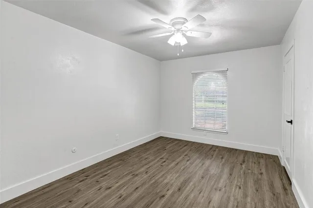 an empty room with wooden floor and window