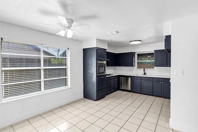 a large kitchen with a window and stainless steel appliances