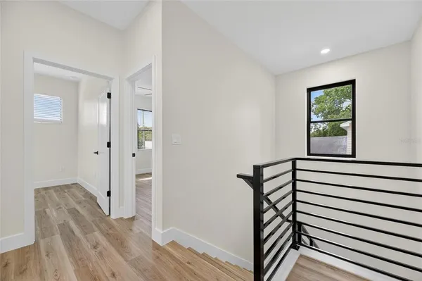 a view of a hallway with wooden floor and staircase