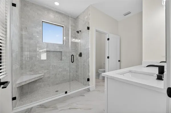 a bathroom with a shower sink and mirror