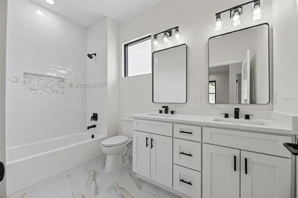 a bathroom with a double vanity sink mirror double and a bathtub