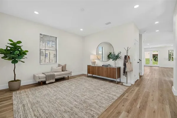 a living room with furniture a potted plant and a wooden floor