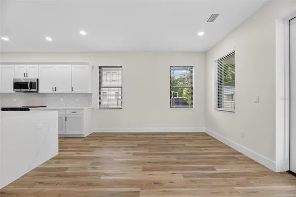 a view of a kitchen with wooden cabinet and an empty room