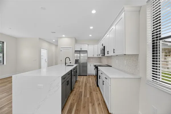 a kitchen with stainless steel appliances a sink stove and cabinets