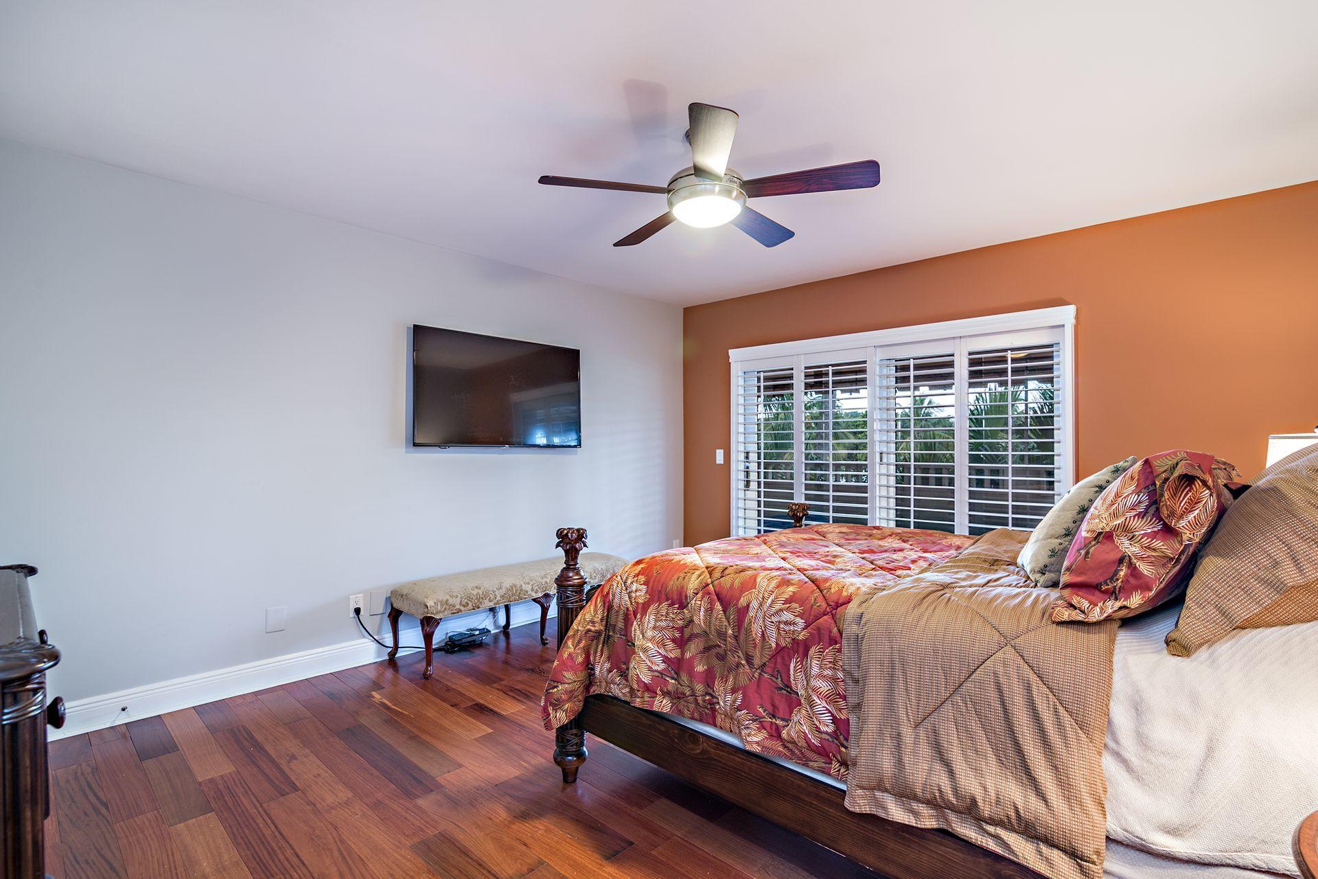 220 Celestial Way, Unit 1 Juno Beach, FL 33408 - Photo 12 of 35 a bedroom with a bed a flat screen tv and a window