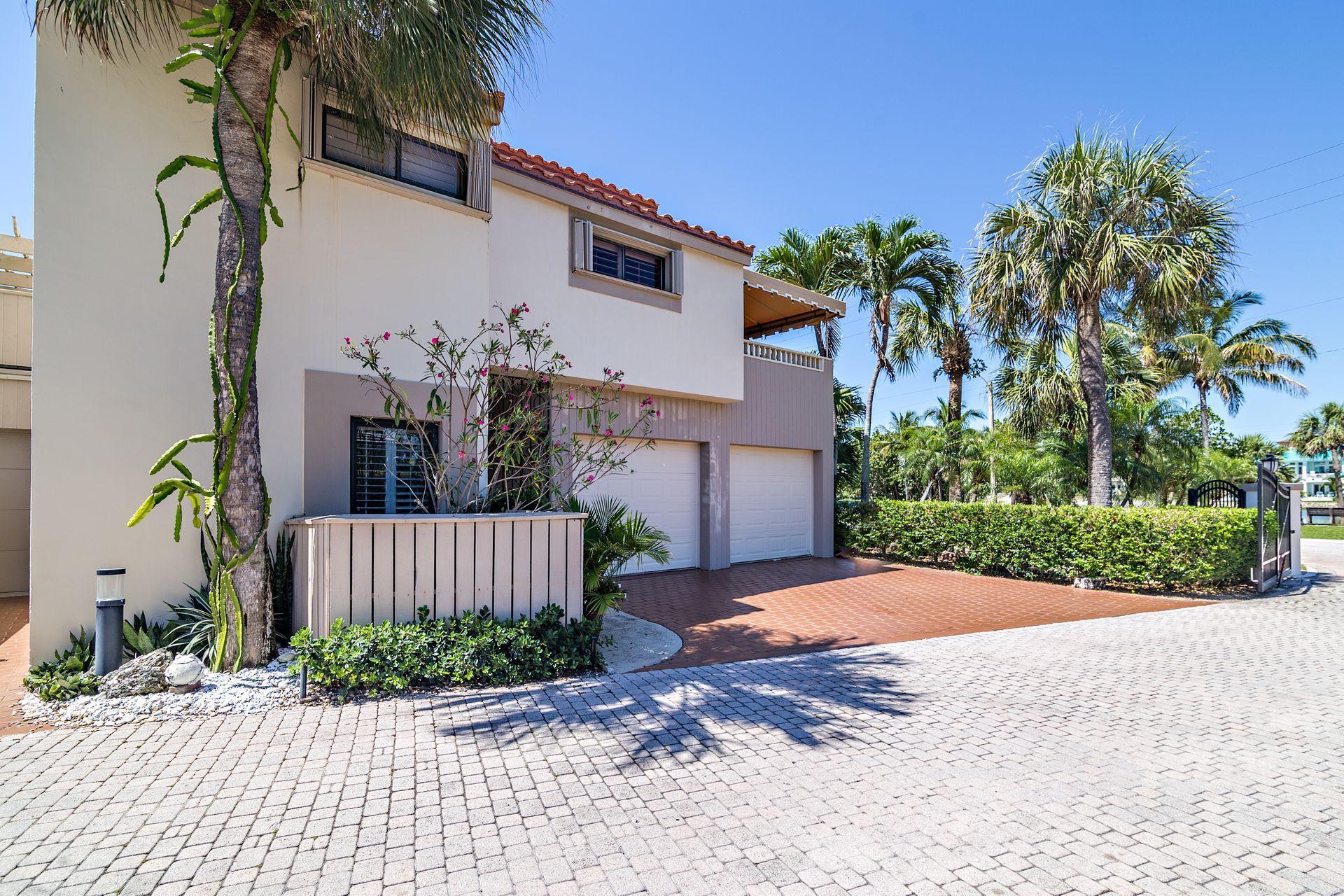 220 Celestial Way, Unit 1 Juno Beach, FL 33408 - Photo 13 of 35 a front view of a house with a yard and a garage
