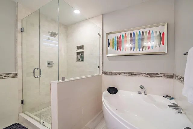 a bathroom with a tub a sink and the shower