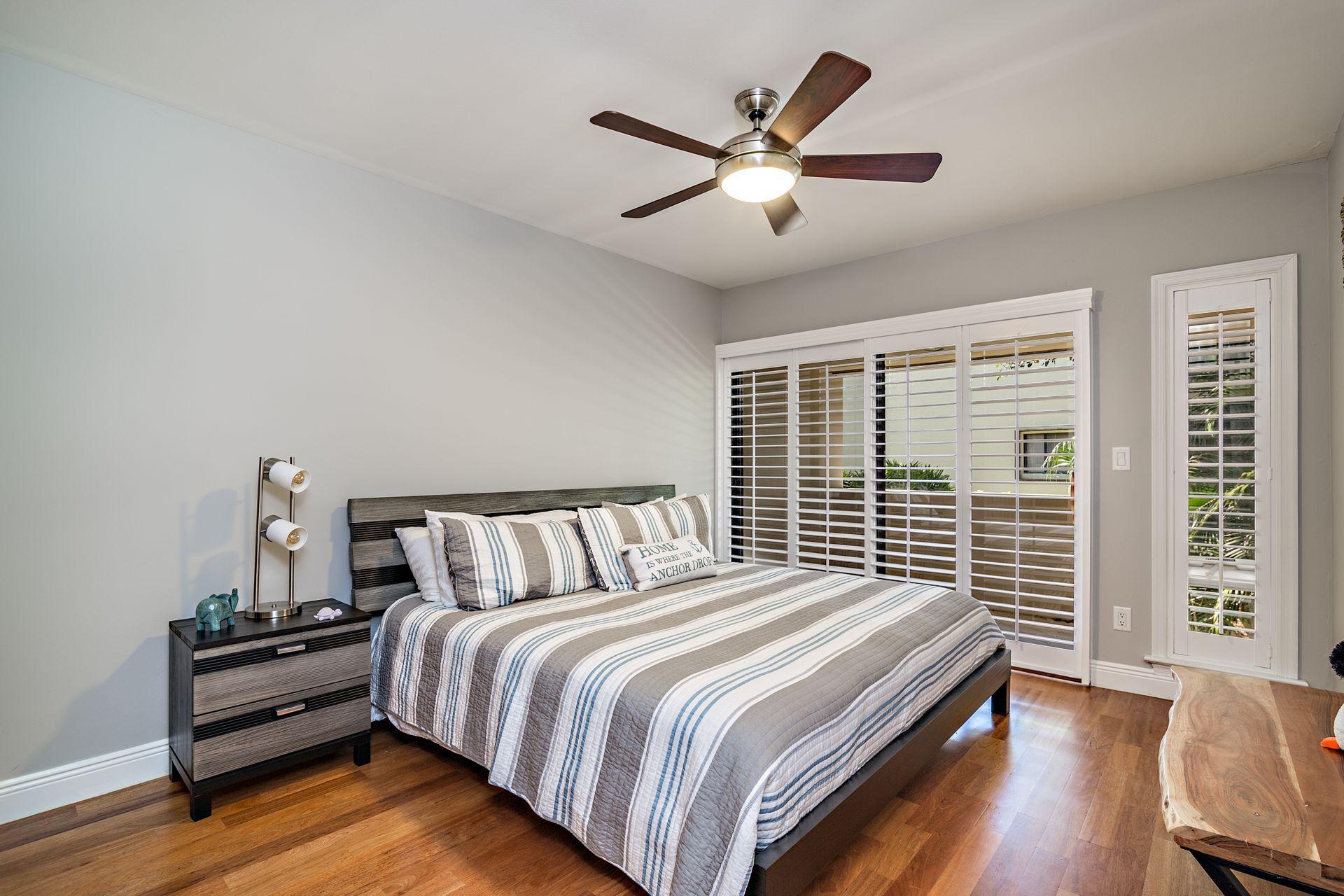 220 Celestial Way, Unit 1 Juno Beach, FL 33408 - Photo 20 of 35 a bedroom with a bed and a large window