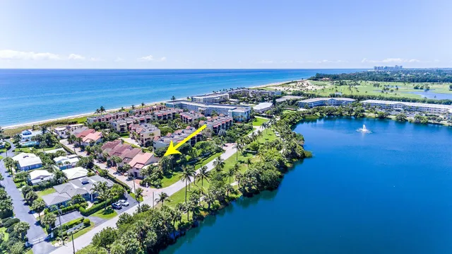 an aerial view of ocean and residential houses with outdoor space
