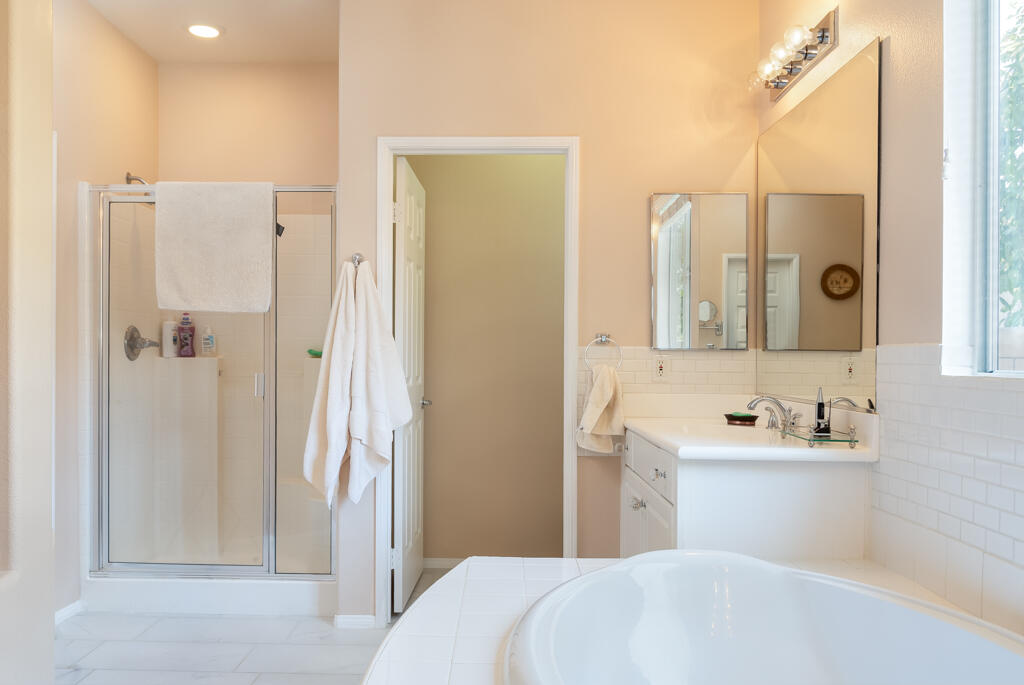 82539 Grant Drive Indio, CA 92201 - Photo 23 of 34 a en suite bathroom with a sink a mirror and a shower
