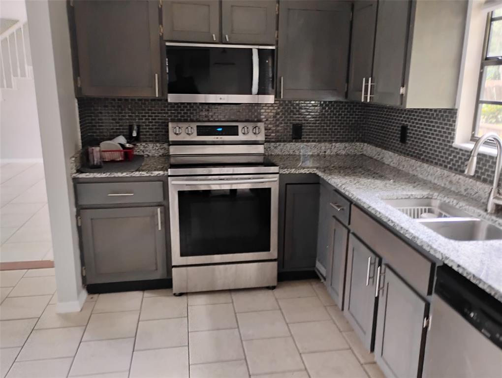10911 Northwest 31st Place Gainesville, FL 32606 - Photo 13 of 27 a kitchen with a stove and a microwave