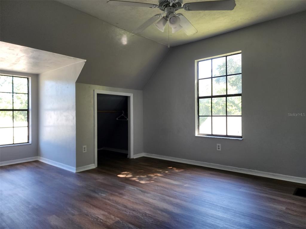 10911 Northwest 31st Place Gainesville, FL 32606 - Photo 18 of 27 an empty room with wooden floor closet and windows