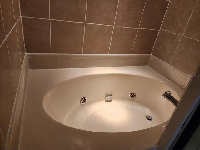 a bathroom with a granite countertop toilet sink and mirror