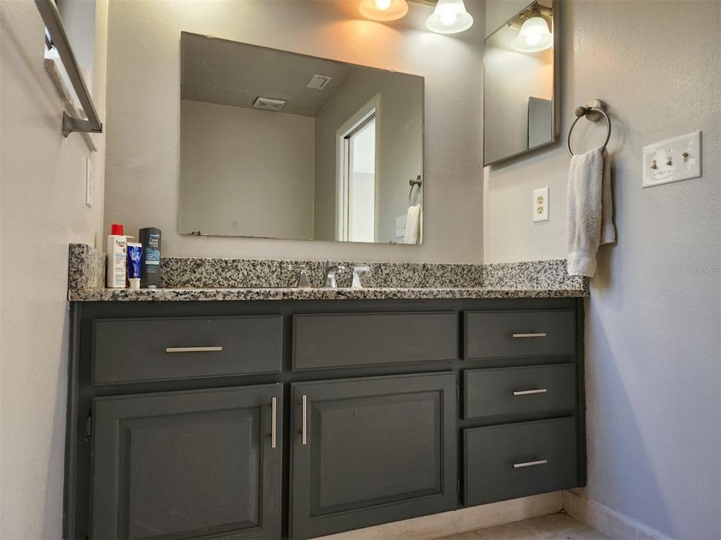 10911 Northwest 31st Place Gainesville, FL 32606 - Photo 4 of 27 a bathroom with a granite countertop sink and mirror