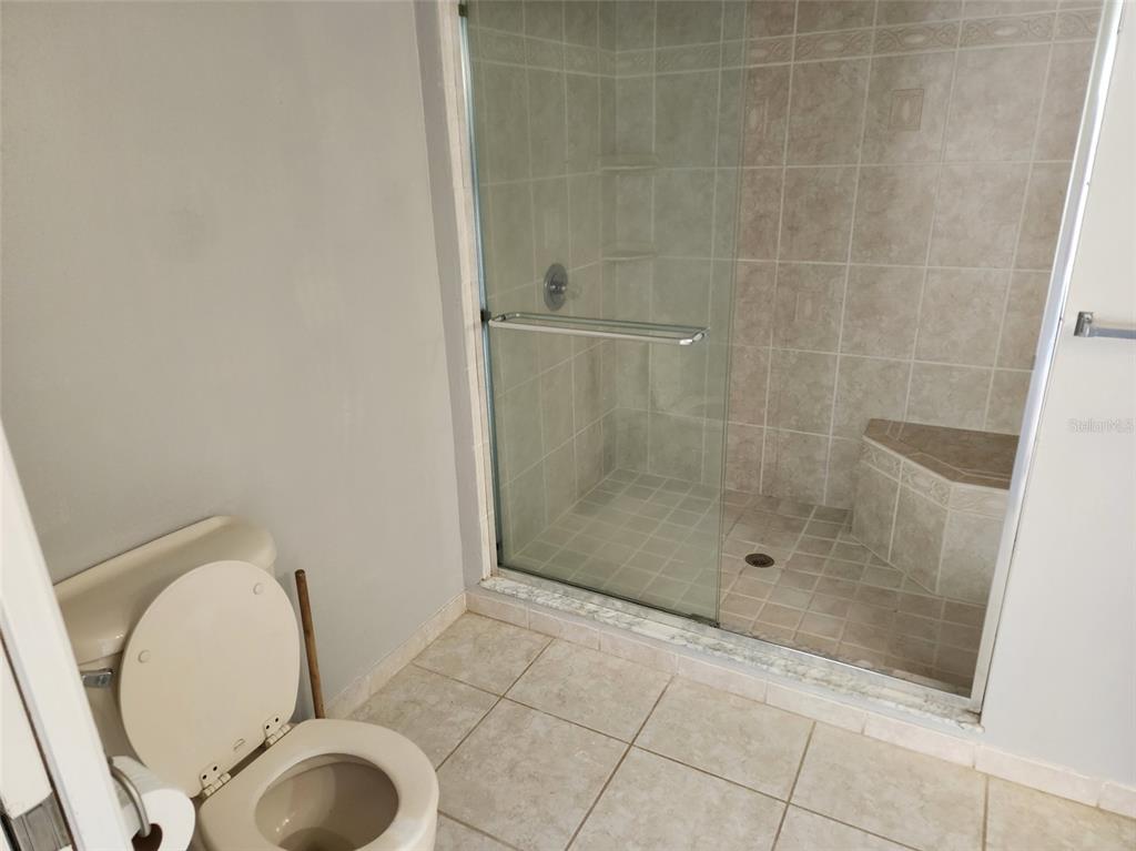 10911 Northwest 31st Place Gainesville, FL 32606 - Photo 5 of 27 a bathroom with a granite countertop bathtub shower and toilet