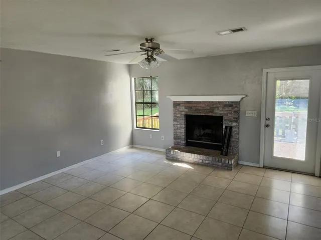 an empty room with fireplace and windows