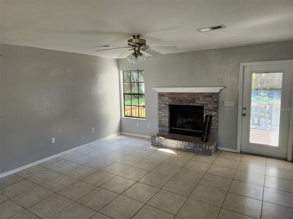 10911 Northwest 31st Place Gainesville, FL 32606 - Photo 8 of 27 an empty room with fireplace and windows