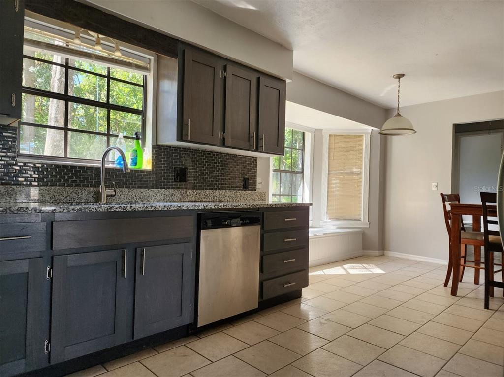 10911 Northwest 31st Place Gainesville, FL 32606 - Photo 10 of 27 a kitchen with granite countertop a sink and a stove top oven