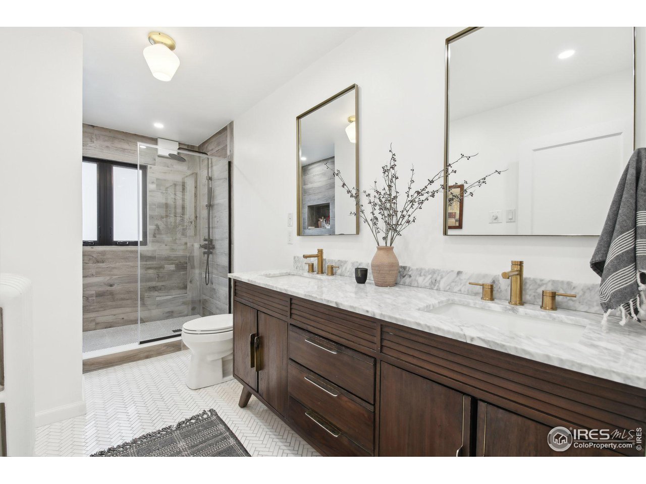 861 13th Street Boulder, CO 80302 - Photo 20 of 36 a bathroom with a granite countertop sink a toilet a mirror and shower