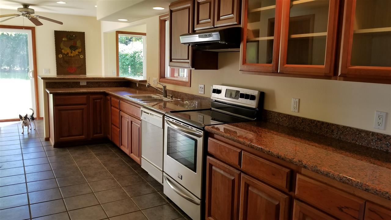 121 Oili Road Haiku, HI 96708 - Photo 14 of 24 a kitchen with stainless steel appliances granite countertop a stove a sink and a microwave