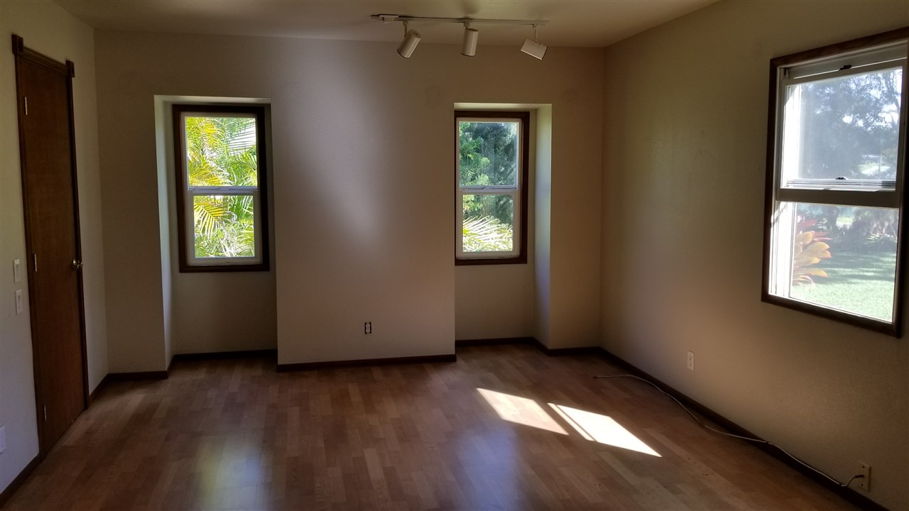 121 Oili Road Haiku, HI 96708 - Photo 17 of 24 an empty room with wooden floor and windows