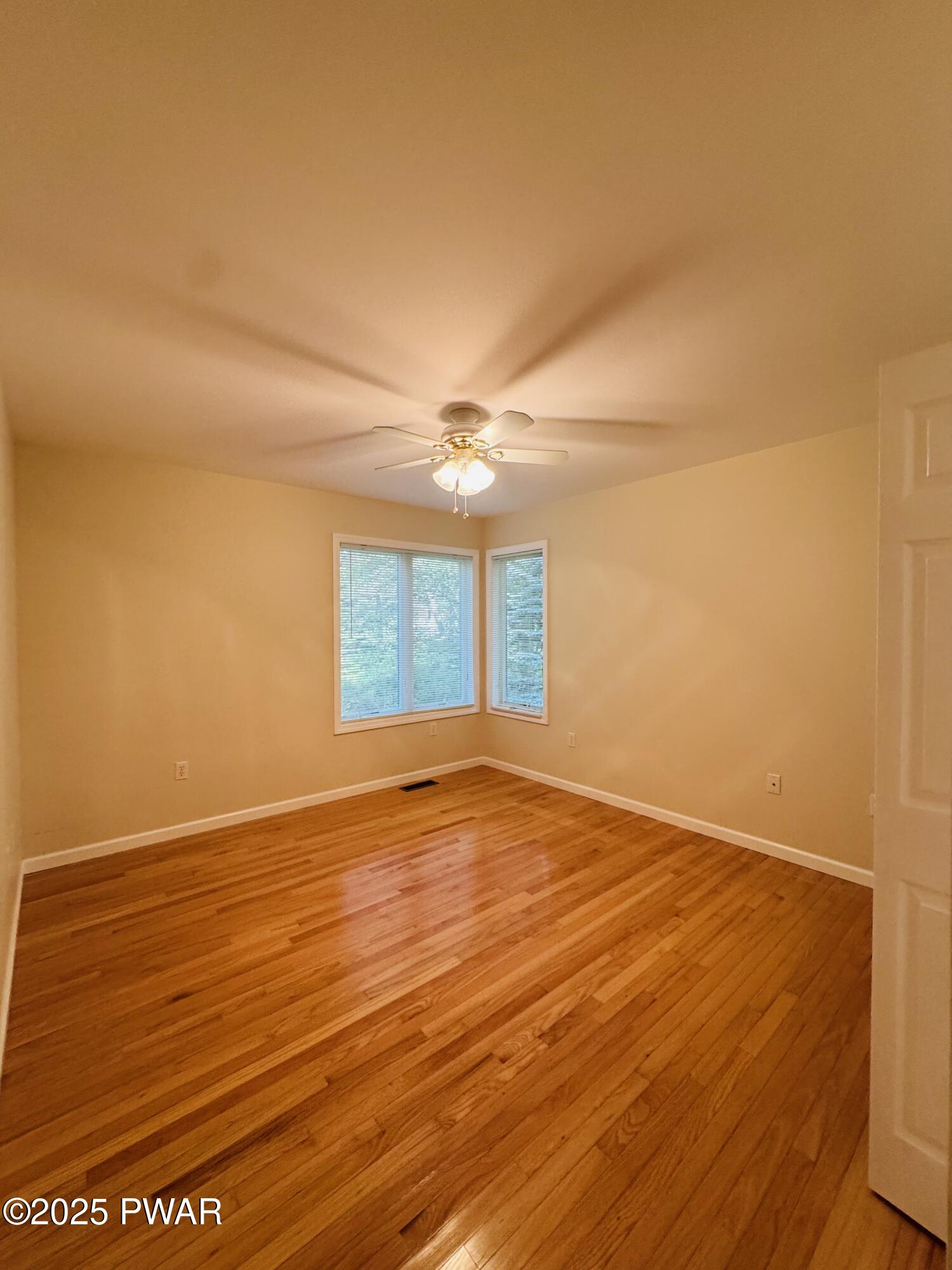 137 Rodeo Drive Hawley, PA 18428 - Photo 25 of 68 an empty room with wooden floor and windows
