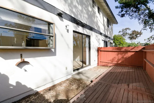 a view of backyard with wooden fence and large trees