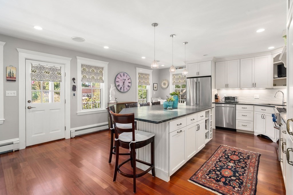 319 Sherman Street Canton, MA 02021 - Photo 4 of 29 a kitchen with stainless steel appliances granite countertop a refrigerator a sink dishwasher and white cabinets with wooden floor