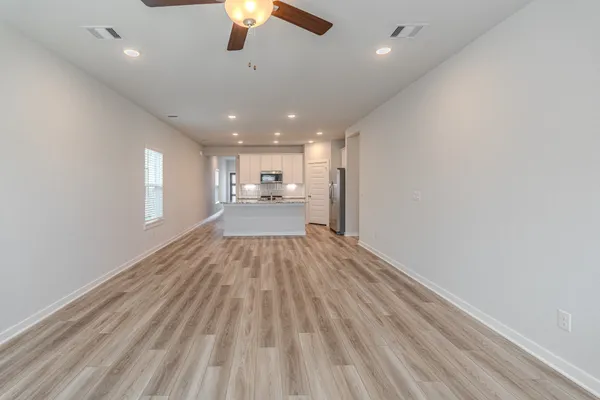a view of empty room with wooden floor