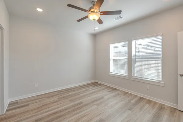 an empty room with a window and a fan