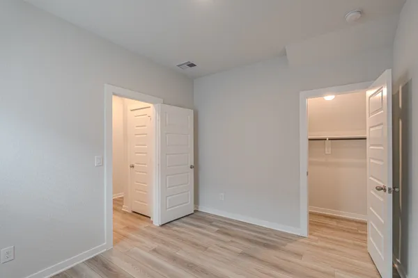 an empty room with wooden floor & closet
