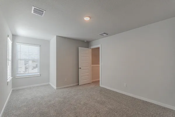 an empty room with windows and closet