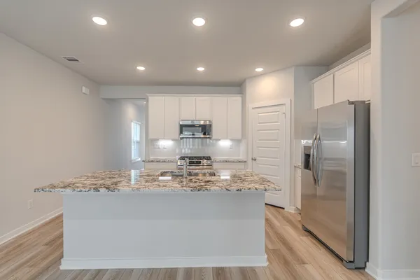 a kitchen with kitchen island a counter top space cabinets and stainless steel appliances
