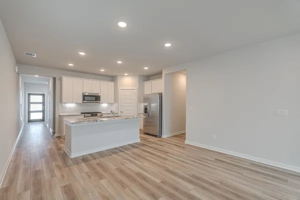 a kitchen with stainless steel appliances granite countertop a refrigerator and a stove top oven