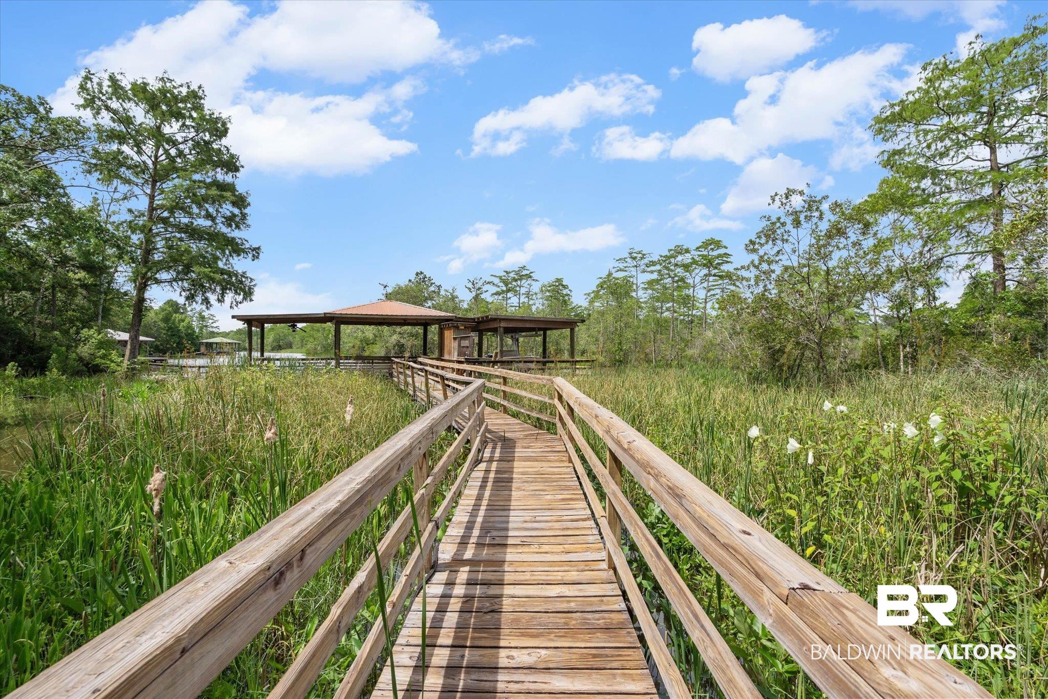 3500 Venetia Road Mobile, AL 36605 - Photo 40 of 56 Wood-plank boardwalk extending over lush marshland toward a covered, open-air structure