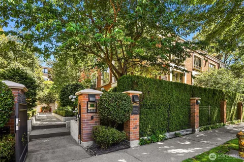 a front view of a house with a yard and tree s