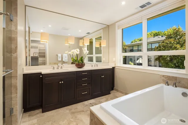 a bathroom with a granite countertop sink a potted plant and a shower