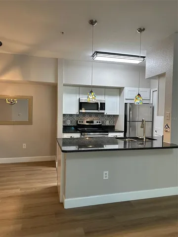 a kitchen with stainless steel appliances granite countertop a sink a stove and a refrigerator