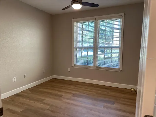 a view of a room with wooden floor and windows