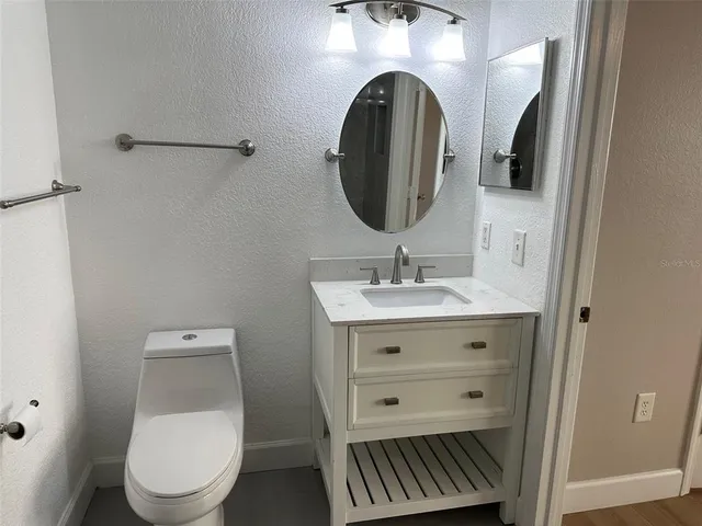 a bathroom with a toilet a sink and mirror